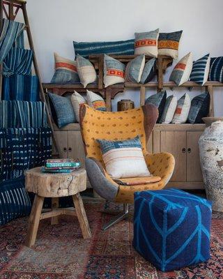 Interior shot of Sunnyside store in the River Arts District of Asheville NC. Vintage worldly textiles, mid century modern chairs, and books!