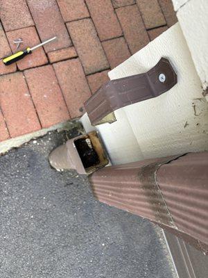 Clogged gutter causing water pouring down walkway and leaking into garage.