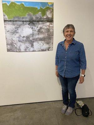 An artist with her work at the current 516 Art "Migration" show