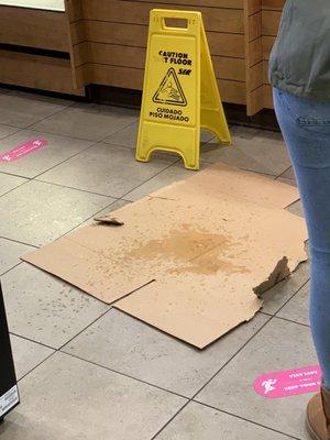 Customer spilled drink in floor and they cover it with cardboard