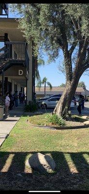 People waiting outside to see Dr. Nguyen on 7/18/20. Patients coughing, no social distancing.