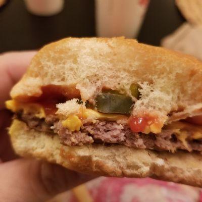 Black Hair in burger. Cooked between the cheese and patty. Look just the left of the pickle.