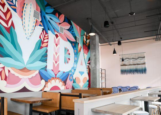 Our main dining area by the bar, featuring a mural by Madrid-based artist collective @BOAMistura