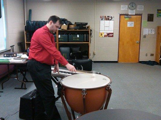 Service Rep Mike tunes a timpani during one of his weekly school visits