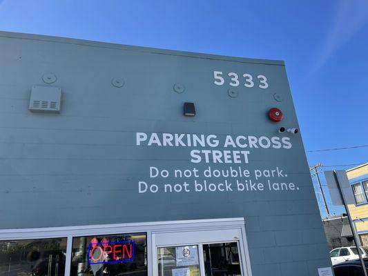 Exterior letting you know where to park of Longfellow Food Pickup in Oakland.