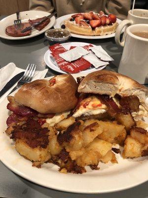 Sausage egg n cheese on a Bagel with home fries.