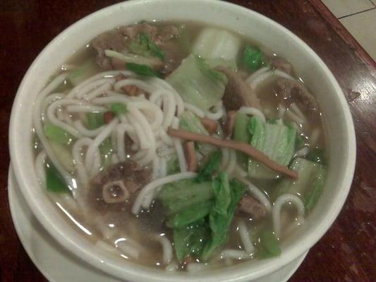 Oxtail noodle soup with strips of squid and lettuce