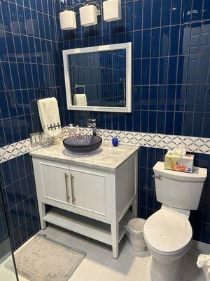 Blue glass vessel sink with waterfall faucet