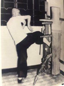 Ip Man poses on the wooden dummy