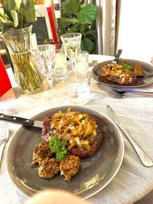 Ribeye Steaks covered in caramelized onions and stuffed mushrooms with pork.