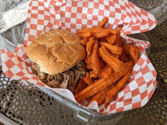 Jumbo pulled pork sandwich with a side of sweet potato fries.