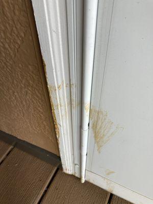 Brown stain on white storm door and frame