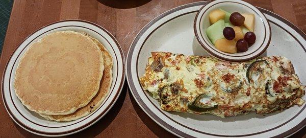 The Townee Omelet with Gyros, Feta, Onions, Tomatoes and jalapeños* (*for a surcharge) with fruits and pancakes.