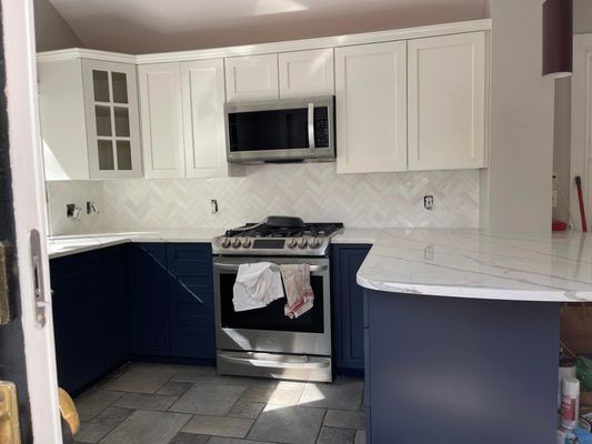 After pictures of cabinets painting 2 different colors. We also installed new backsplash and hardware to all the cabinets