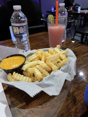 Fries with nacho cheese and one of their cocktails