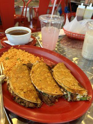 Spanish rice, Birria Estilo Jalisco and sauce, glass of pink lemonade