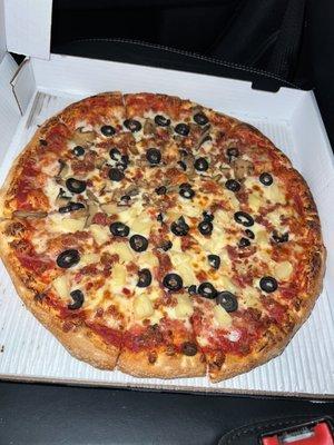 large pizza with black olives bacon, half mushroom half pineapple