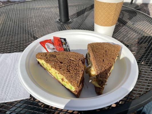 Avocado, egg, and cheese sandwich and hot coffee with cream I guess