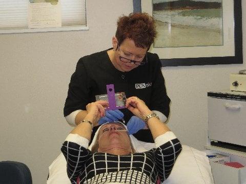 Our esthetician, Kemmi Lee, performing a treatment on a patient. Kemmi specializes in skin care and chemical peels