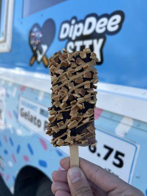 Chocolate pop dipped in dark chocolate with waffle cone and cookie butter drizzle