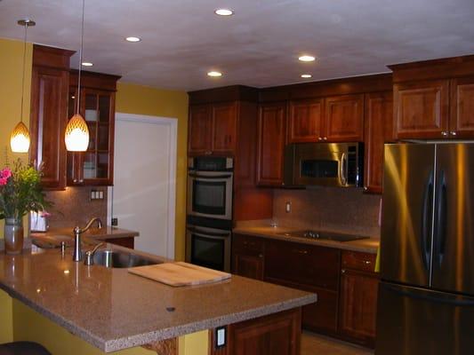 Kitchen remodel with recessed lighting, under cabinet lighting, and hanging pendant lights.