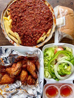 Takeout spread - pasta w/ meat sauce meal, bread & side salad (came w/ meal) & 6 piece bone in wings buffalo - Uber eats