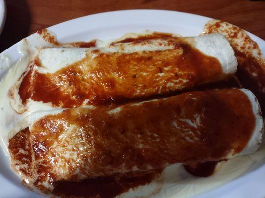 Beeg burritos with red sauce and added queso