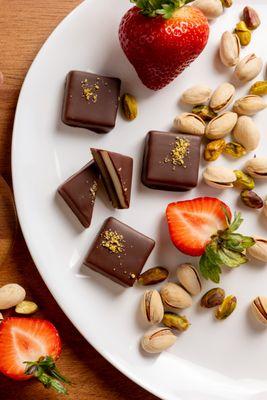 Indulge in our Triple Delight Praline: a fusion of pistachio, almond, and strawberry in creamy white and dark chocolate. Treat yourself!