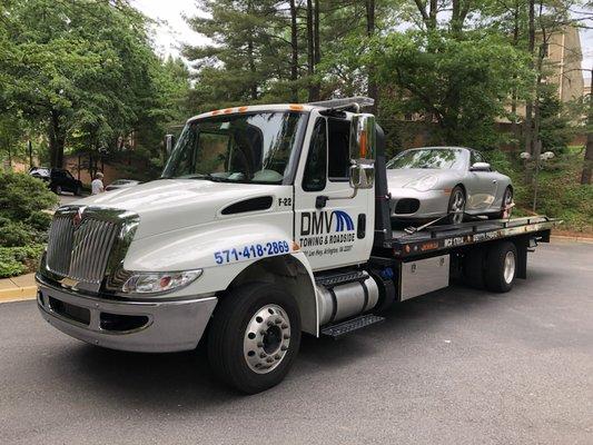 Porsche being tow by our flatbed tow truck that is made with airbags for lowered vehicles and exotics.