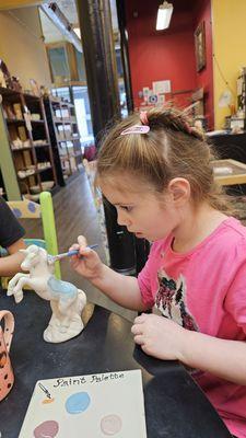 Granddaughter painting a unicorn.