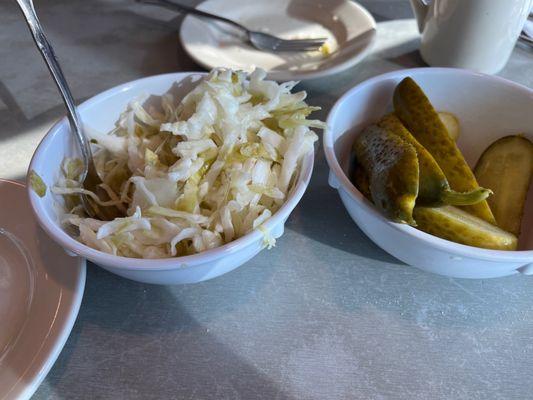 The coleslaw and pickles served with the sandwich duo.