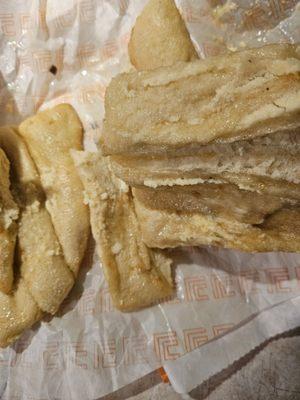 Uncooked Crazy Bread with dirt specs on paper