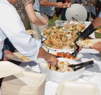 Buffet line with cauliflower ceviche, fruit salad, banh mi