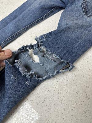 Brand new pair of jeans shredded from a malfunctioning machine. Owners ignoring the issue.