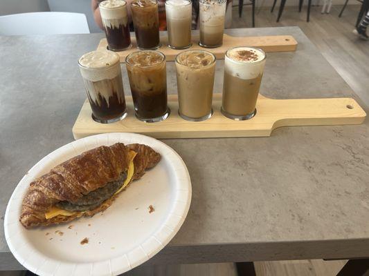 Summer Seasonal coffee flight and their breakfast sandwich, chose sausage on a croissant with spicy aioli