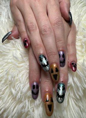 Ms Tina did my nails with powder dip and each nail has a different color cat eye polish and hand drawn halloween designs.