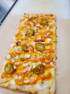 Buffalo Chicken Pizza with jalapenos, onions, blue cheese and buffalo sauce.