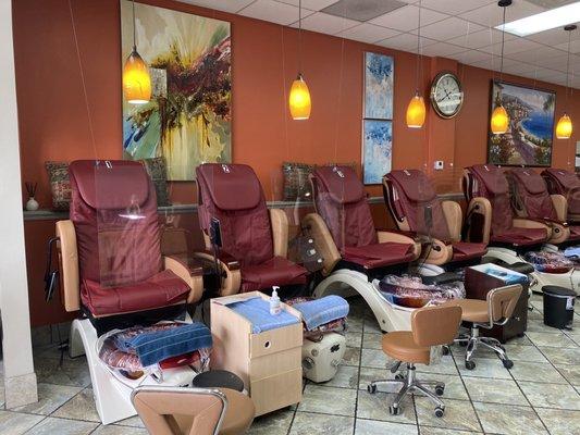 Pedicure chairs with a barrier between client and tech