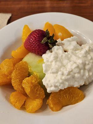 A bowl of fruit salad with cottage cheese.