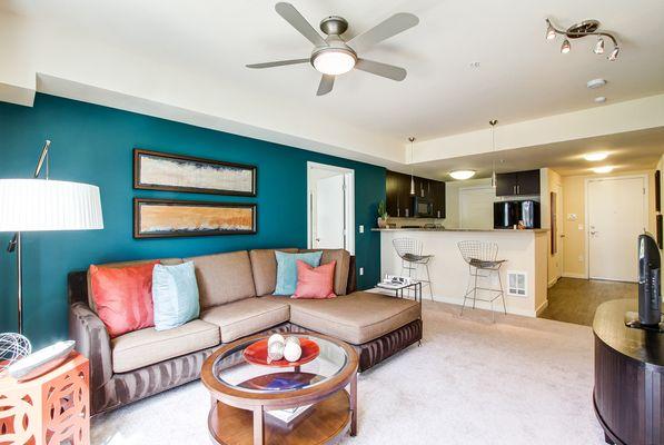 Staged, open layout featuring a living room and kitchen access.