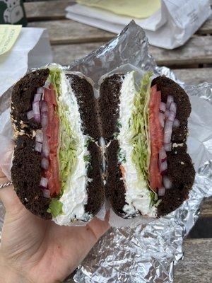 Pumpernickel everything with tofu scallion cream cheese, lettuce, tomato, onion