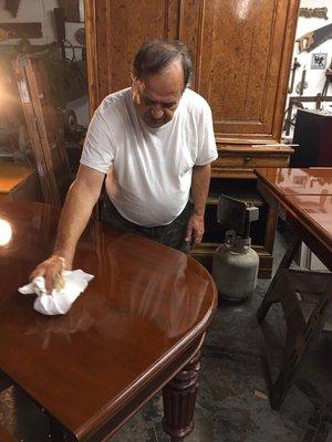 Mauro Fallani IV generation working final step French Polish on antique English table Fallani and Sons