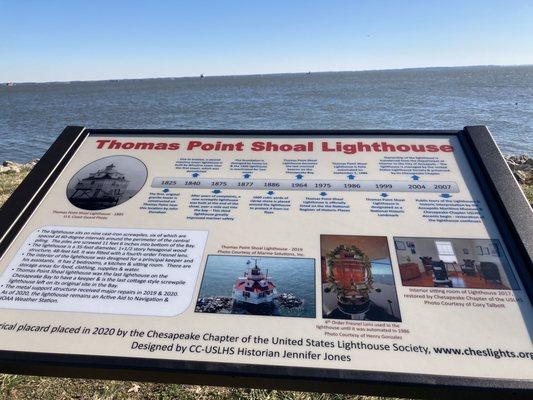 Signage in the forefront and lighthouse in the background