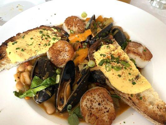 Scallops and mussels served with bread to soak up the broth.