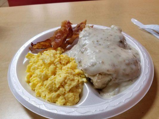 Biscuits and gravy with scrambled eggs and bacon.