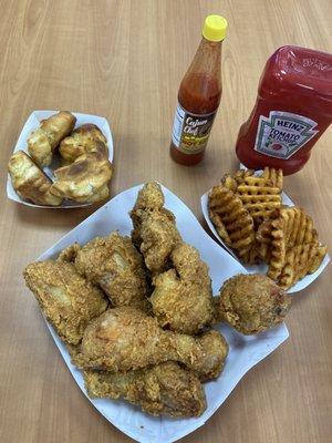 Fried chicken with honey buttered biscuits and a side of fries.