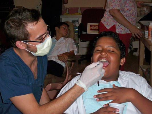 Dr. Douglas Baldwin performing dental treatment on one of his young patients.