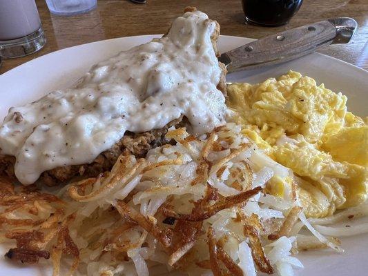 Chicken fried steak with gravy, soft scrambled eggs and hash browns