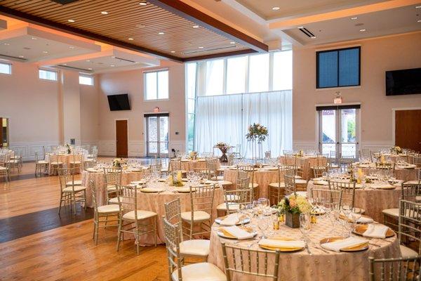 Elevated ceilings, wood floor, and expansive windows in the ballroom