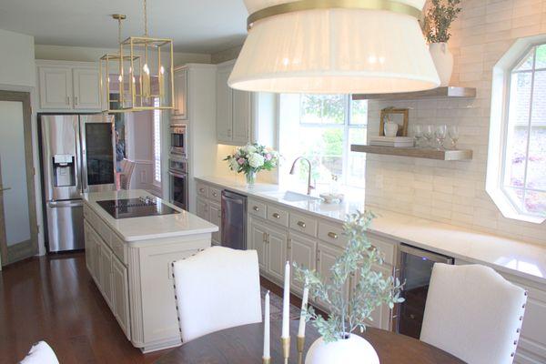 Cream and White kitchen complete with 3 unique light fixtures, floating custom wooden cabinets and a wine cooler.